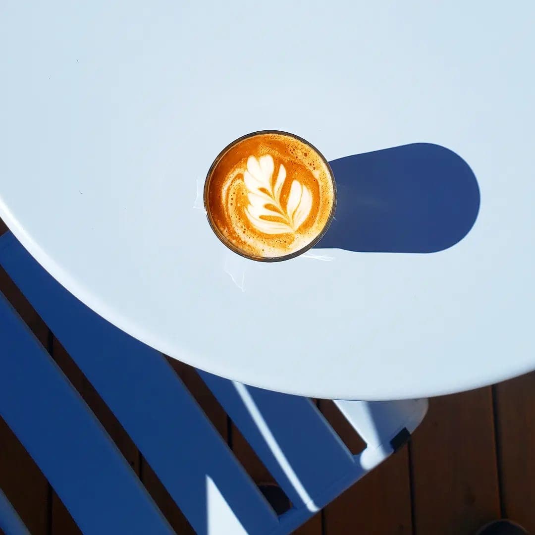 Latte au soleil sur table bleue