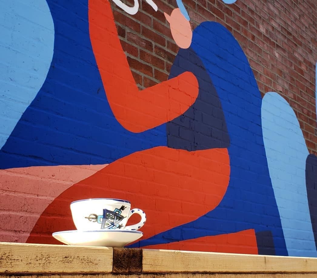 Tasse devant la murale du quartier